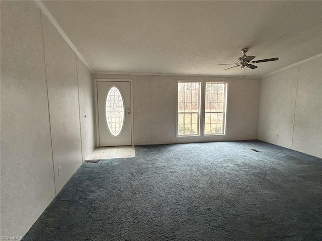 foyer with ceiling fan, carpet, and ornamental molding