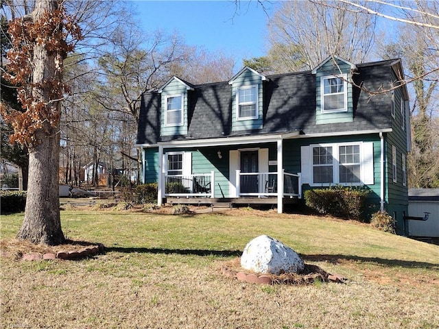 view of front of house featuring a gambrel roof, a porch, and a front yard