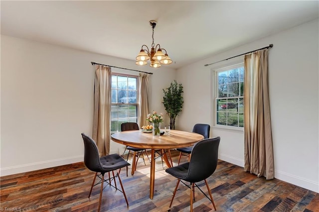 dining room with a notable chandelier, baseboards, and dark wood-type flooring