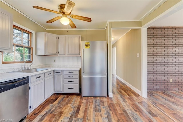 kitchen with wood finished floors, stainless steel appliances, light countertops, and a sink