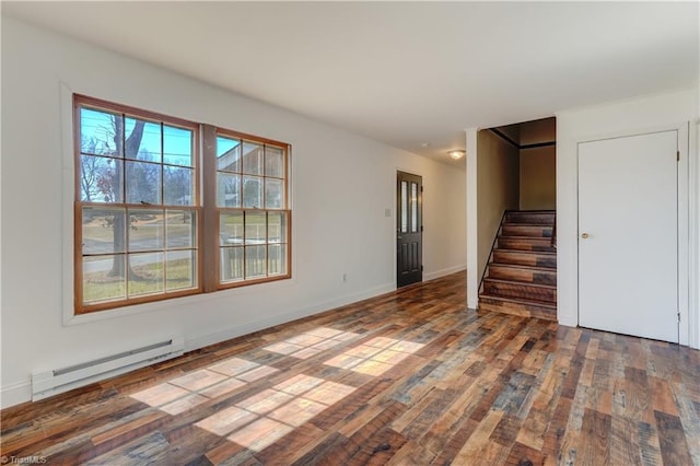 interior space with a wealth of natural light, baseboard heating, stairway, and hardwood / wood-style floors