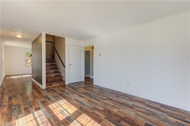 unfurnished room featuring dark wood-style floors, stairway, and baseboards