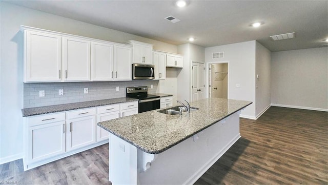 kitchen featuring stainless steel appliances, a kitchen breakfast bar, a kitchen island with sink, and white cabinets