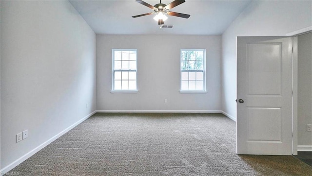 empty room featuring ceiling fan and dark colored carpet