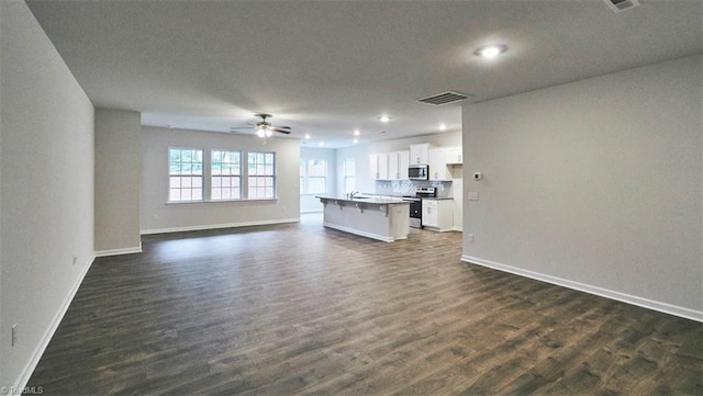 unfurnished living room with dark wood-type flooring and ceiling fan