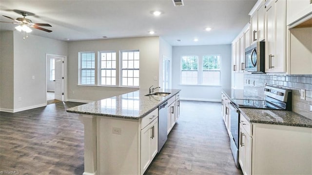 kitchen featuring white cabinetry, appliances with stainless steel finishes, a kitchen island with sink, and sink