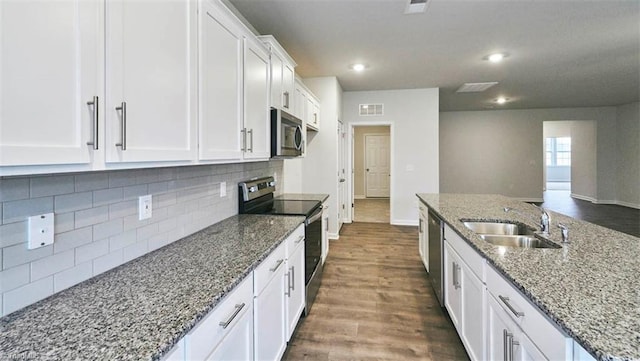 kitchen featuring dark stone countertops, appliances with stainless steel finishes, sink, and white cabinets