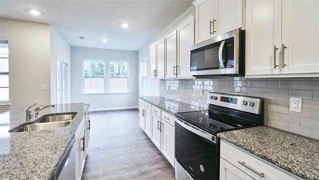 kitchen featuring white cabinetry, sink, decorative backsplash, light stone counters, and stainless steel appliances