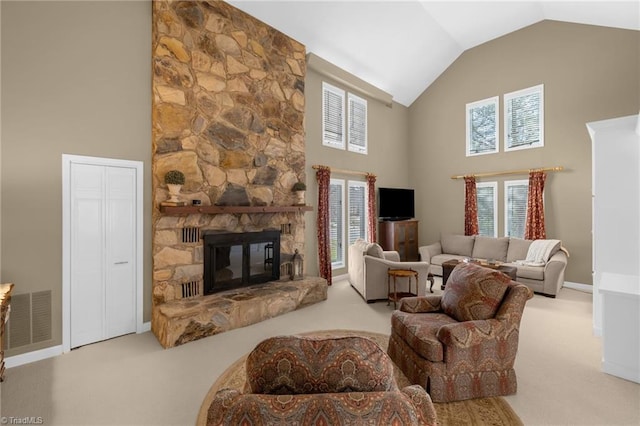 living room featuring high vaulted ceiling, a stone fireplace, visible vents, and light colored carpet