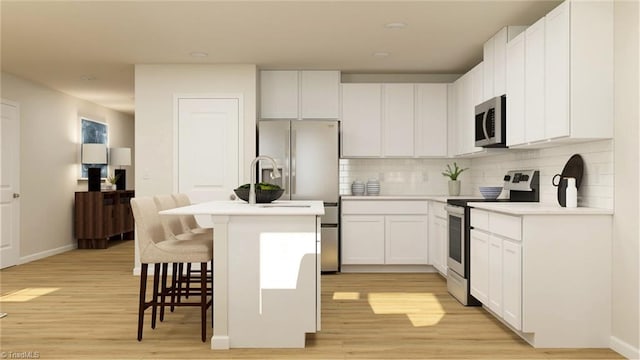 kitchen featuring stainless steel appliances, a kitchen island with sink, light countertops, and white cabinetry