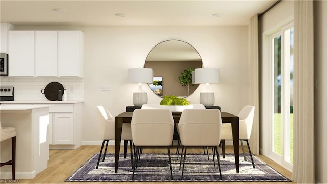 dining area with light wood-style flooring and baseboards