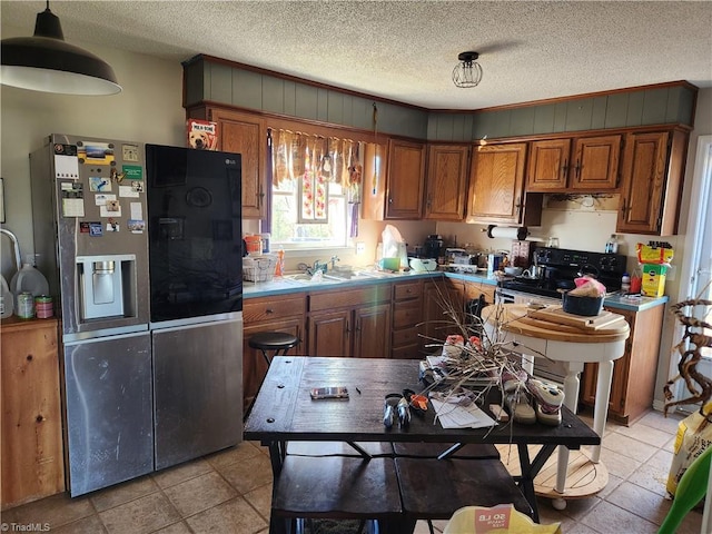 kitchen with sink, stainless steel fridge with ice dispenser, a textured ceiling, and light tile patterned floors