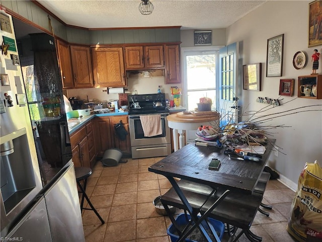 kitchen featuring electric range, light tile patterned floors, fridge with ice dispenser, and a textured ceiling