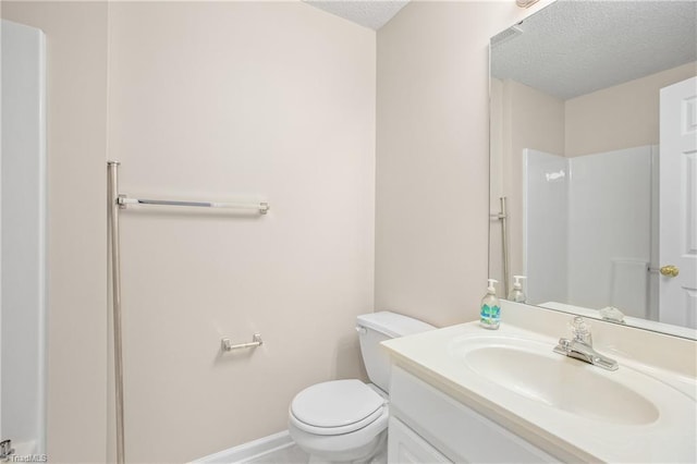 bathroom with vanity, walk in shower, a textured ceiling, and toilet