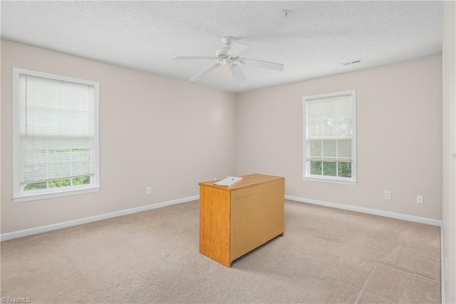 carpeted spare room with ceiling fan and a textured ceiling