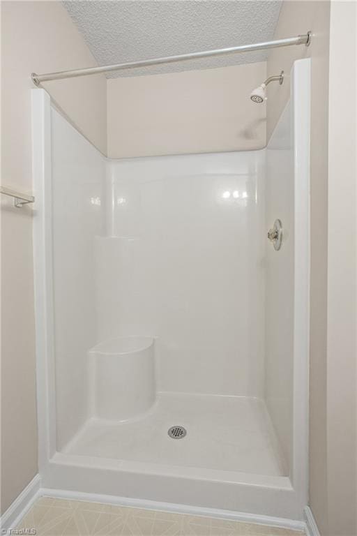 bathroom with a textured ceiling and walk in shower