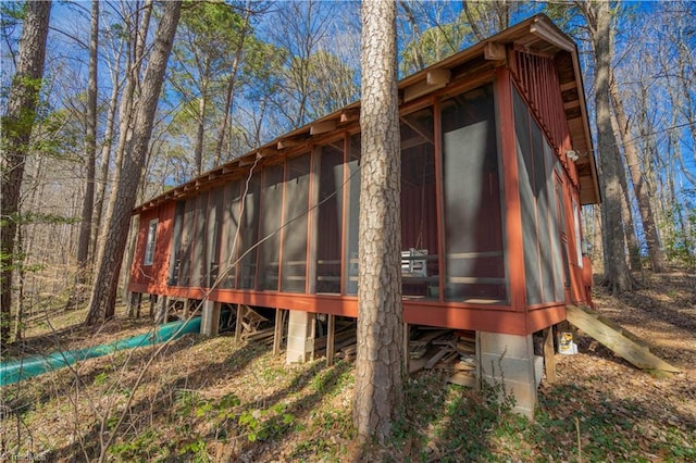 view of property exterior with a sunroom