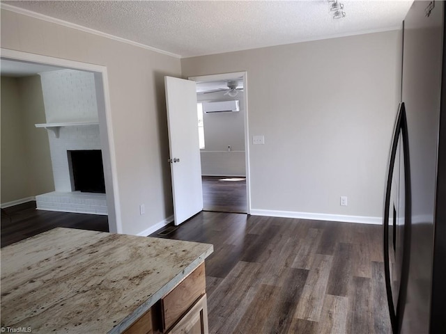 251 Marshall Farm Rd, Mount Airy, NC 27030 - unfurnished living room featuring an AC wall unit, dark wood-type flooring, crown molding, a textured ceiling, and a brick fireplace
