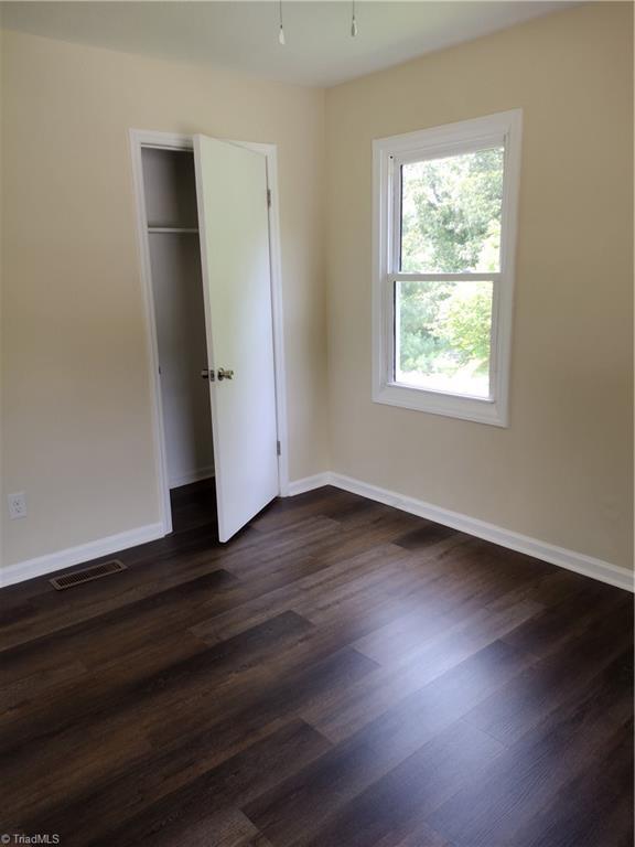 251 Marshall Farm Rd, Mount Airy, NC 27030 - unfurnished bedroom featuring dark wood-type flooring and a closet