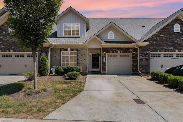 view of front of home with a garage, concrete driveway, and roof with shingles