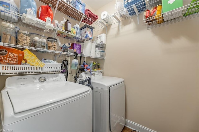 laundry area with laundry area, washing machine and clothes dryer, and baseboards