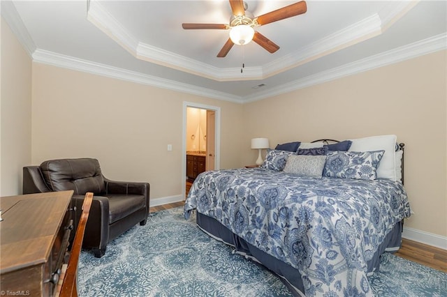 bedroom with baseboards, a ceiling fan, wood finished floors, a tray ceiling, and crown molding