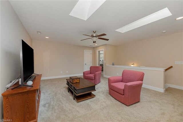 carpeted living area with a skylight, baseboards, a ceiling fan, and recessed lighting