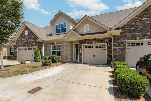 craftsman inspired home featuring a garage, stone siding, driveway, and a shingled roof