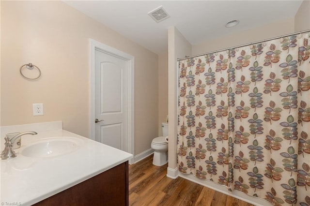 bathroom with visible vents, toilet, wood finished floors, curtained shower, and vanity