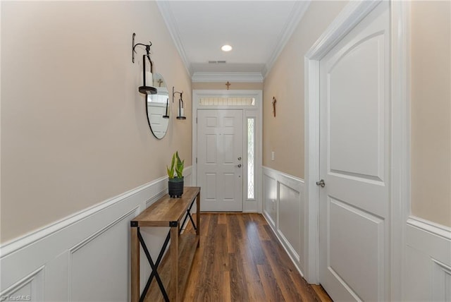 doorway to outside with a decorative wall, a wainscoted wall, visible vents, dark wood-style floors, and crown molding