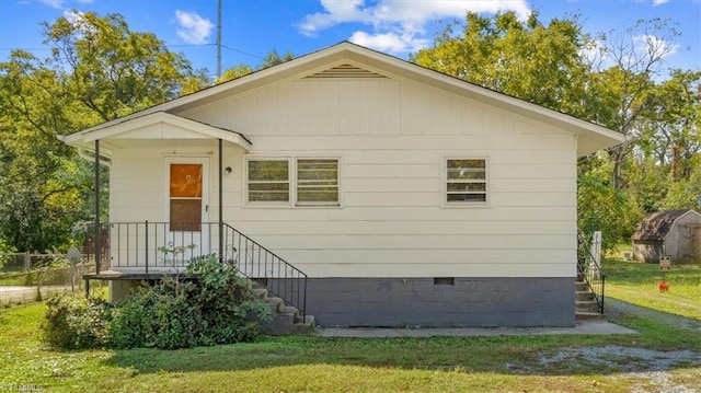 view of side of property with a yard and a storage unit