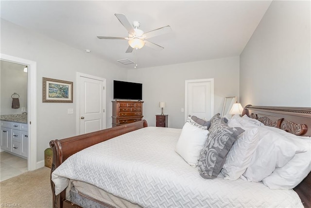 bedroom featuring light carpet, ensuite bath, visible vents, and a ceiling fan