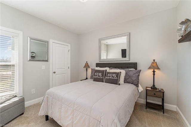 bedroom with light carpet and baseboards