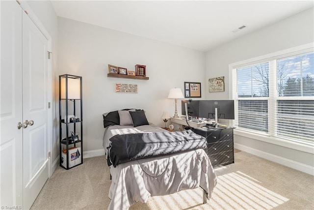 bedroom with light carpet, visible vents, and baseboards