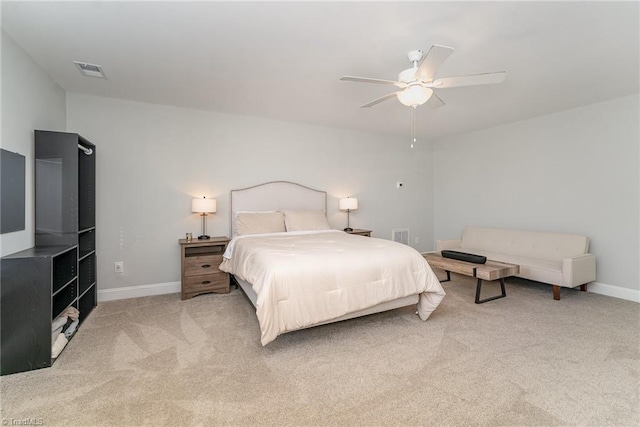 bedroom with baseboards, a ceiling fan, visible vents, and light colored carpet