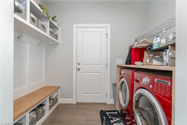 clothes washing area featuring laundry area, light wood-style flooring, baseboards, and washer and dryer