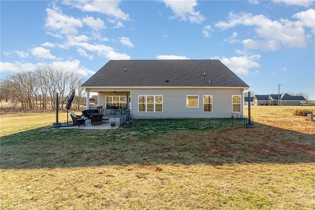 rear view of house with a yard, ceiling fan, roof with shingles, and a patio