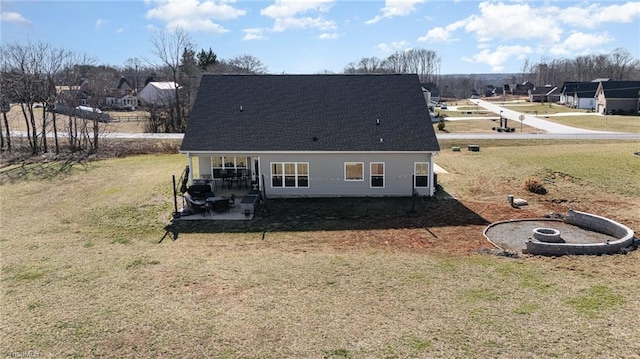 rear view of house featuring a lawn, a patio area, and a residential view