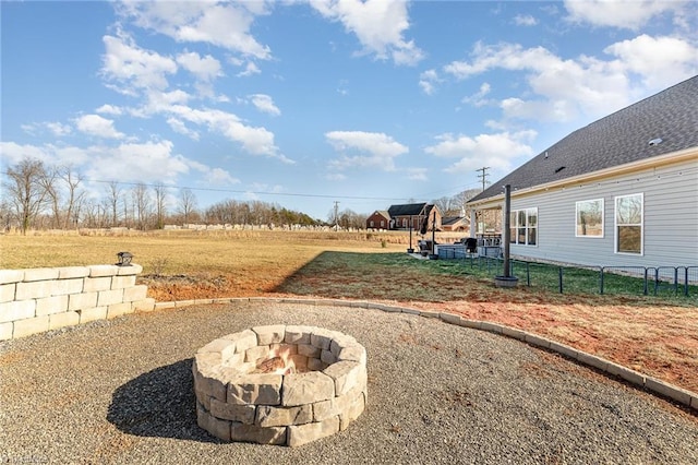 view of yard featuring an outdoor fire pit and fence