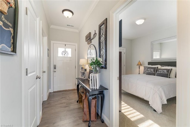 interior space with visible vents, baseboards, light wood-style flooring, and crown molding