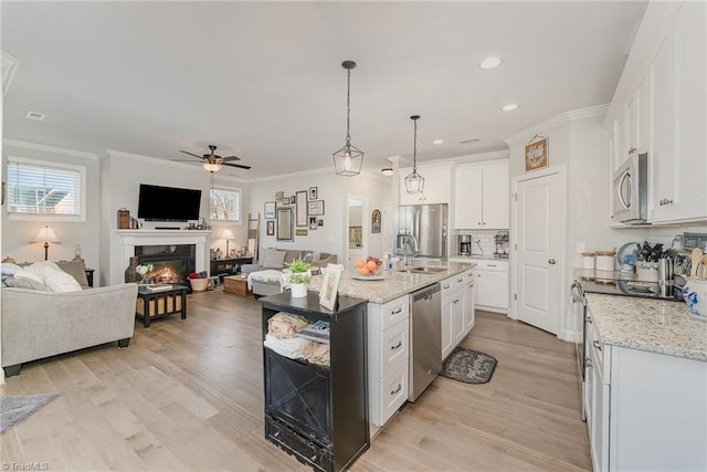 kitchen with stainless steel appliances, a kitchen island with sink, and white cabinets