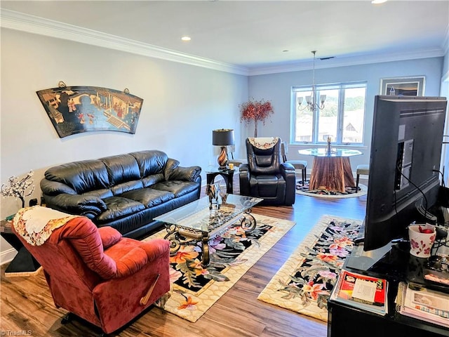 living room with wood-type flooring, crown molding, and a chandelier