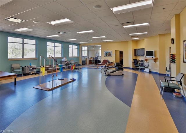 gym with a paneled ceiling