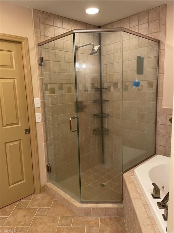 full bathroom featuring a shower stall and a bath