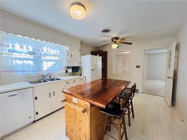 kitchen featuring ceiling fan, sink, white cabinets, and white appliances