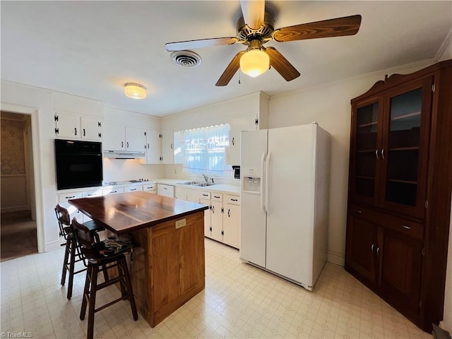 kitchen with a breakfast bar, white cabinetry, sink, a center island, and white appliances