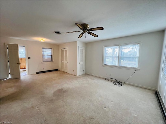 unfurnished bedroom with multiple closets, ceiling fan, light colored carpet, and baseboard heating