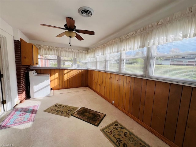 unfurnished sunroom with washer / dryer and ceiling fan