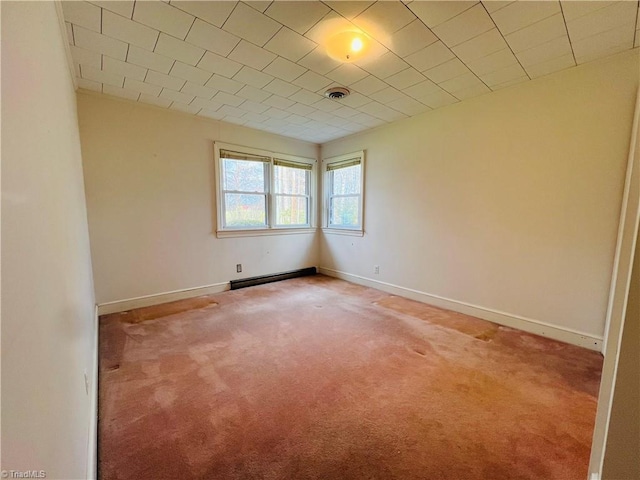 unfurnished room featuring carpet flooring and a baseboard heating unit