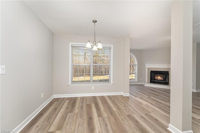 unfurnished dining area with light wood-type flooring and a chandelier